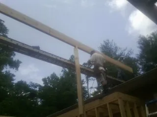 Carpenter setting a ridge beam over a new addition frame — Ice Dam Removal by Roofing Brothers in Fort Knox