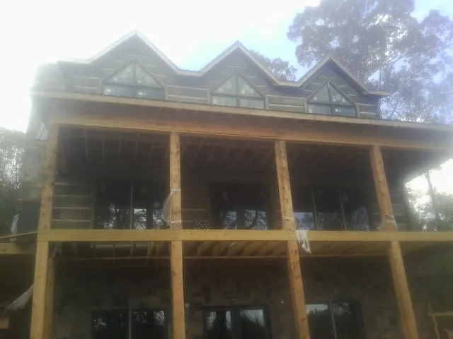Dormers and porch framing on a large log home under construction — Roof Coating work by our crew in Fort Knox