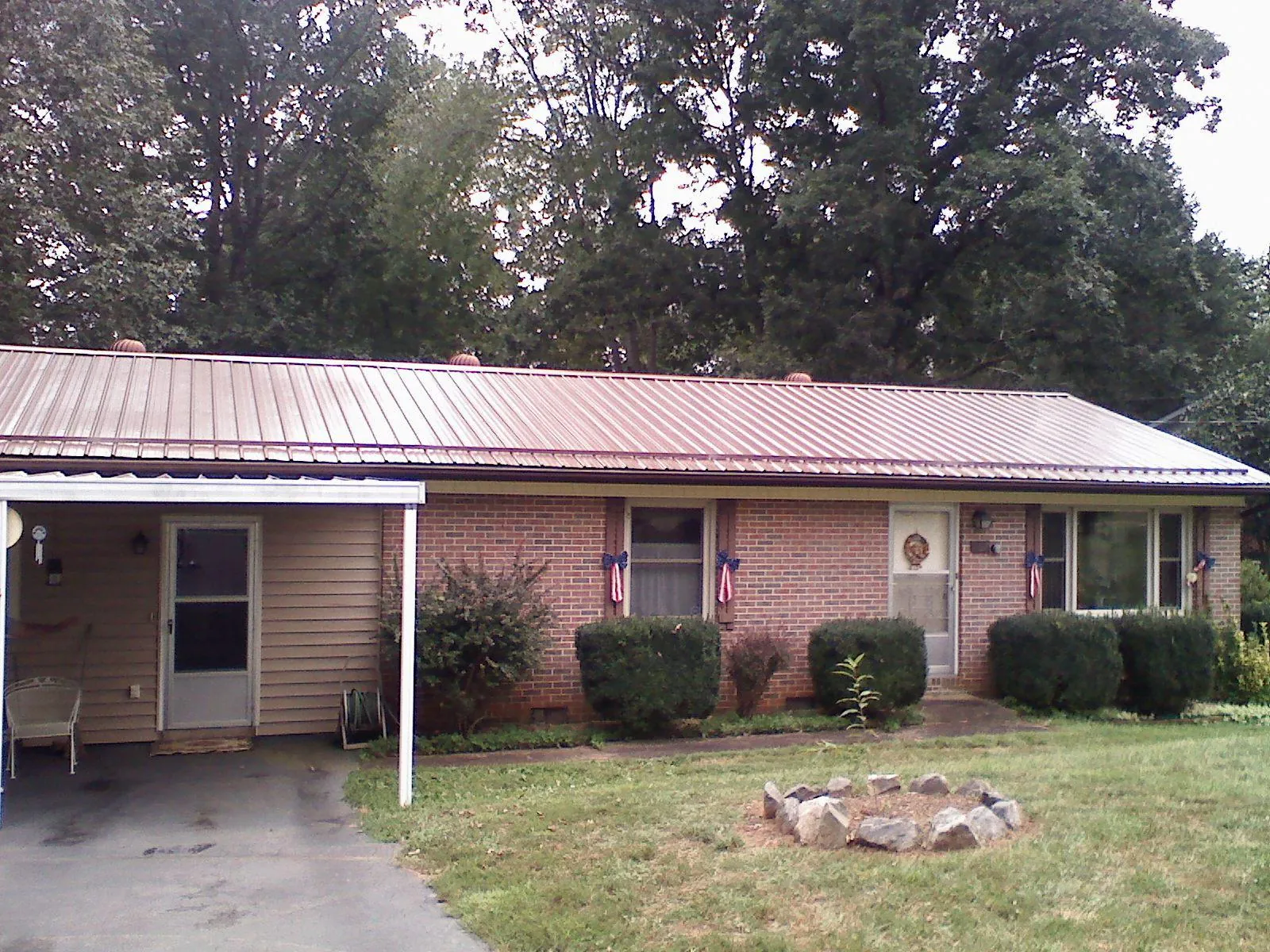 Bronze metal roof and carport on a brick ranch home — Roof Repair work by our crew in Fort Knox